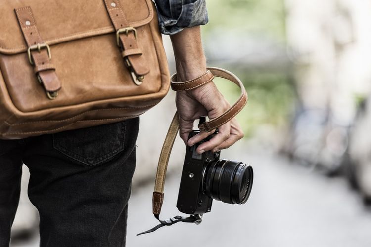 Ilustrasi Seorang Fotografer dengan membawa peralatan kamera( poto : kompas edukasi )