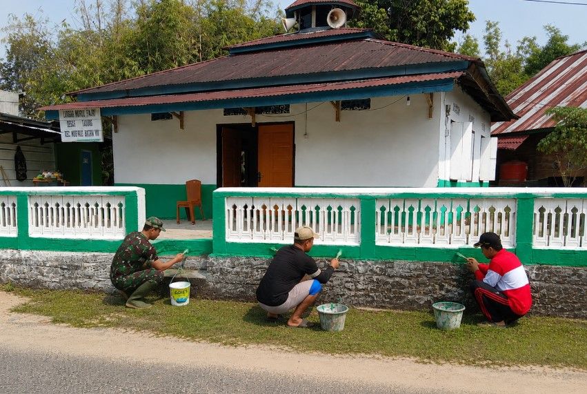 Personel Satgas TMMD ke-129 Kodim 0416/Bute bersama warga mengecat pagar Langgar Nurul Fajri di Desa Tanjung Agung, Kecamatan Muko Muko Bathin VII, Kabupaten Bungo, Rabu (12/8/2026).(poto: oegopost.id).