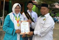 Suryadi, S.Ag., Wakil Kepala MAN 1 Bungo Bidang Humas dan TIK, menyerahkan piagam penghargaan kepada Nurhafizah Nadya atas prestasinya meraih Medali Emas bidang Matematika.(poto: jambiprima.com).