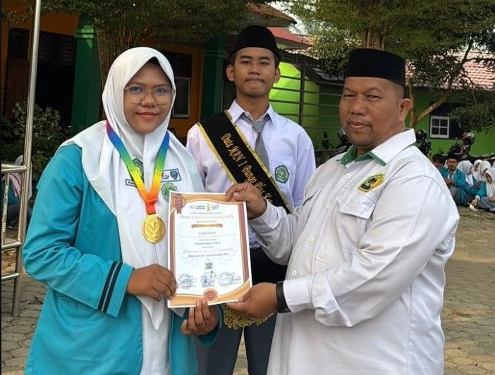 Suryadi, S.Ag., Wakil Kepala MAN 1 Bungo Bidang Humas dan TIK, menyerahkan piagam penghargaan kepada Nurhafizah Nadya atas prestasinya meraih Medali Emas bidang Matematika.(poto: jambiprima.com).