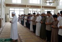 Ilustrasi Seorang imam memimpin shalat berjamaah dengan khusyuk di saf terdepan sebuah masjid.(poto: AI).