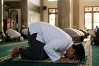 Ilustrasi Jemaah pria bersujud khusyuk di atas karpet masjid saat menunaikan ibadah shalat berjamaah.(poto: AI).