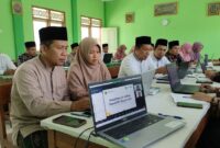 Ilustrasi: Pendidik pesantren fokus menyimak materi pelatihan kecerdasan buatan daring via laptop di ruang belajar, Jumat (16/10).(poto: AI).