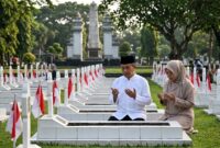 Ilustrasi Warga memanjatkan doa khidmat di depan makam pahlawan saat peringatan Hari Pahlawan di Taman Makam Pahlawan (TMP).(poto: AI).