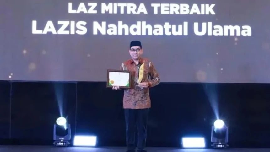 Ketua LAZISNU PBNU Ali Hasan Al Bahar memegang piagam dan piala Grand Baznas Awards 2026.(poto: nuonline.com).